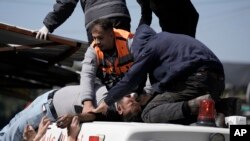 An injured Palestinian is lifted onto an ambulance during clashes with Israeli forces in the West Bank city of Nablus, Wednesday, Feb. 22, 2023. 