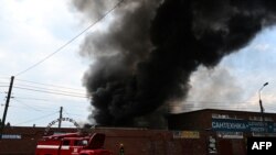 Firefighters work to control flames at the central market of Sloviansk on July 5, 2022, following a suspected missile attack. 