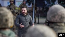 This handout photograph taken and released by Ukrainian Presidential press service on Nov. 14, 2022, shows Ukrainian President Volodymyr Zelensky speaking to servicemen during his visit to the newly liberated city of Kherson, following the retreat of Russ