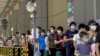 FILE PHOTO: Residents wearing face masks line up to get tested for the coronavirus disease (COVID-19) in Macau, China July 4, 2022.